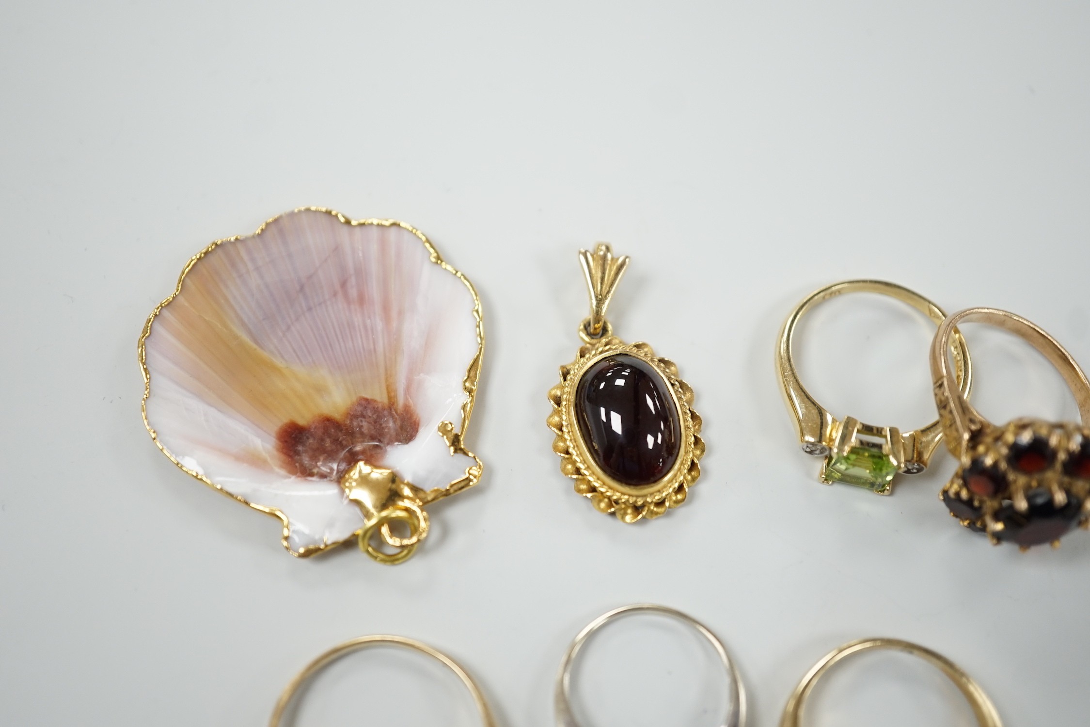 A 9ct and garner cluster set dress ring, size M, gross 4.9 grams, two yellow or white metal and diamond set rings, including half eternity and a yellow metal and garnet set half hoop ring, gross 8.8 grams, a 14k, single